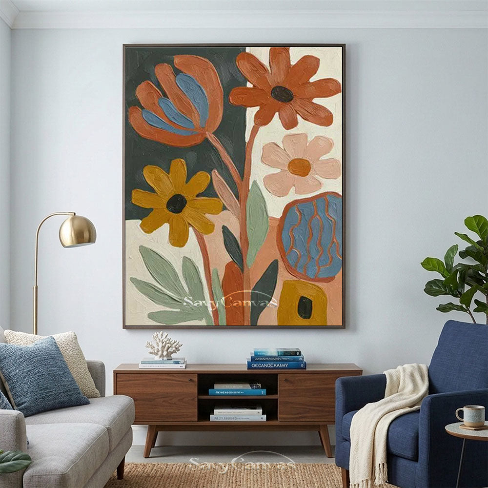 A large hand-painted mid-century modern abstract oil painting depicting various stylized flowers in orange, yellow, and pink on a dark green and white split background, showcased over a console table in a contemporary living room.