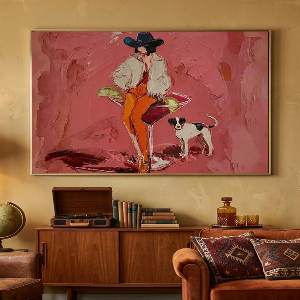 Handcrafted expressionist heavy textured oil painting in a black frame featuring a stylish cowgirl in a black hat sitting on a giant cocktail glass with a spotted dog against a vibrant pink background, ideal for modern living room or fashion wall decor.